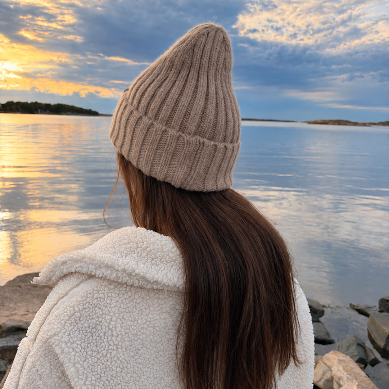 FREJA-mössa i Sand, bakifrån vid havet i kvällsljus